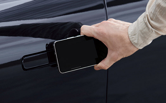차량 도어 손잡이에 스마트폰 태그 하는 모습