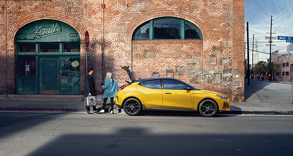 Peoples and side view of yellow veloster parking on the road 