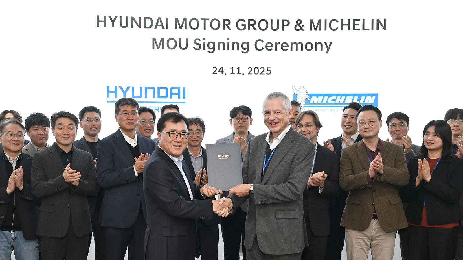 (In the middle, from left) Yongsuk Shin, Vice President and Head of Genesis Engineering Design Center at Hyundai Motor Group, and Georges Levy, Executive Vice President and Head of Asia Pacific Automotive Original Equipment at Michelin, with other participants standing in the background during the MOU signing ceremony