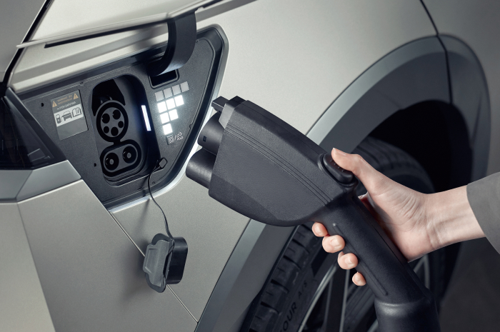 전기차 충전을 위해 충전 케이블을 잡고 있는 모습